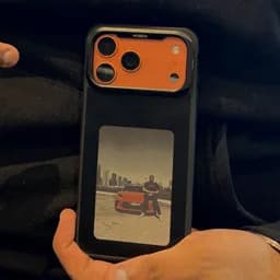 Munsa's Dark Canvas Pro in his hand, a photo of a man beside a car on its panel
