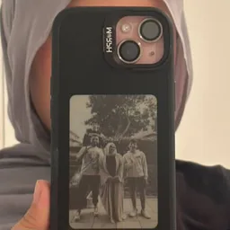 Sama's Dark case held up to a mirror, a family photo on its panel